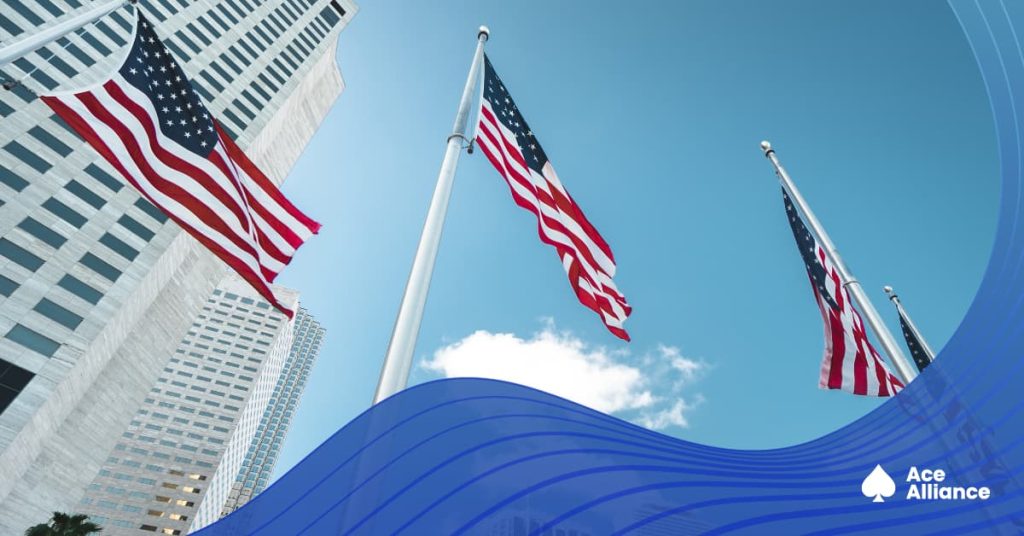 US flags waving outside modern skyscrapers.