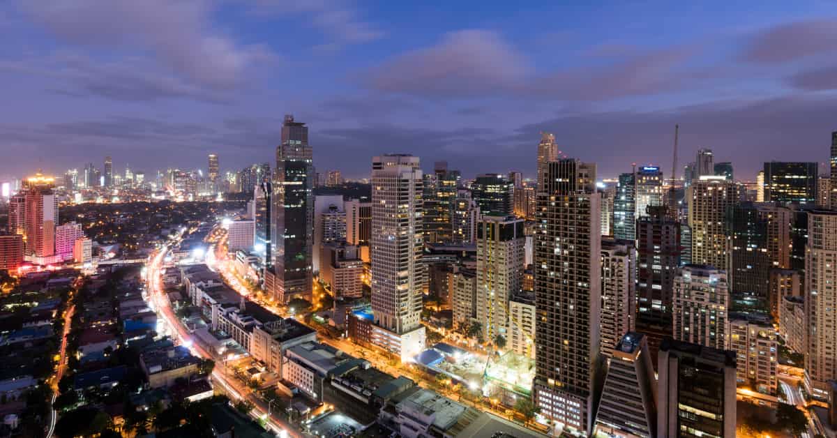 manila skyline at night with city lights and skyscrapers.