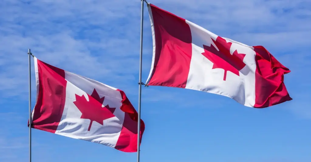 Two Canadian flags waving against a blue sky illustrating Canada’s guidance on sports event contracts