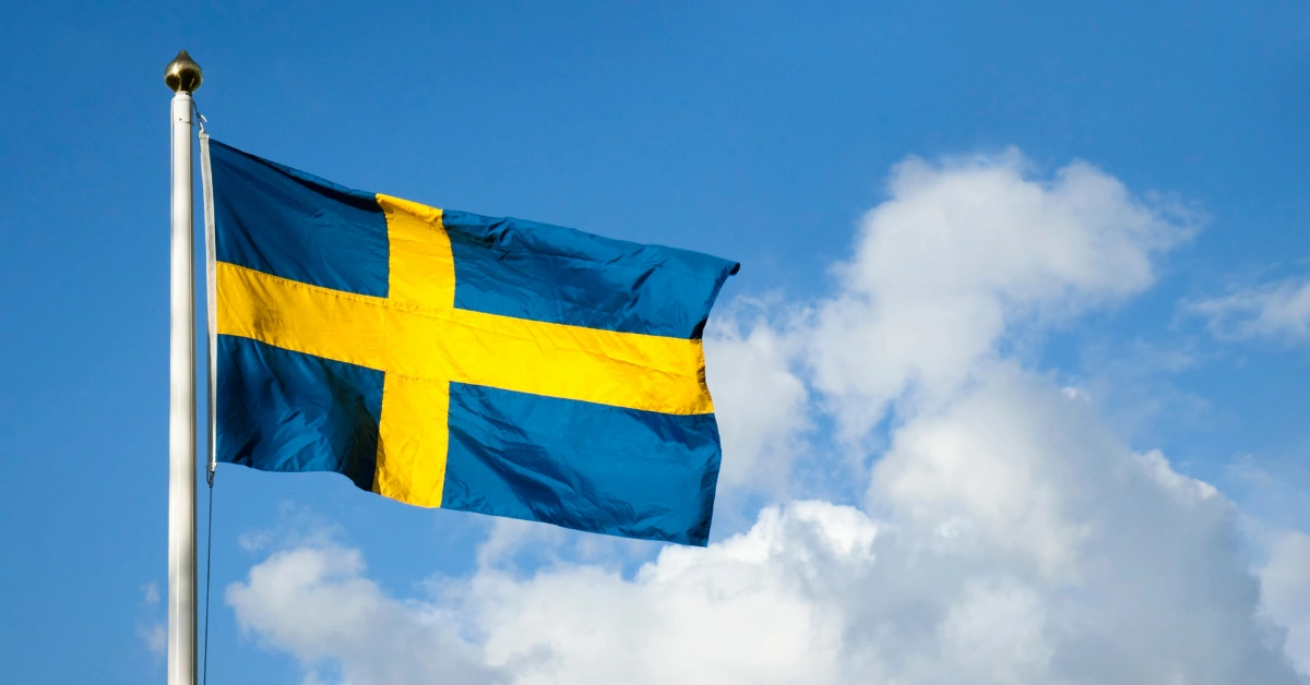 Swedish flag flying against a blue sky as new AML rules take effect for commercial land based gaming